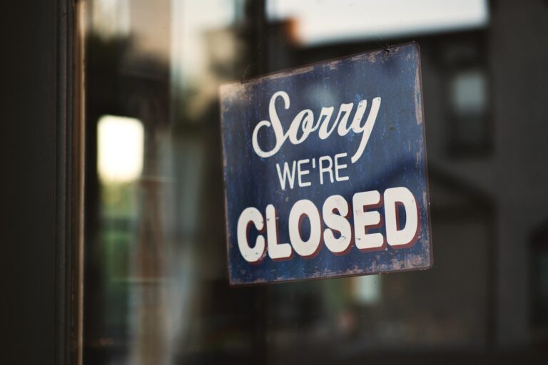 Sorry we're closed signage hanged on glass door